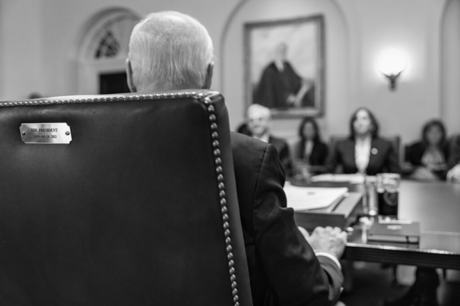 President Biden sitting at a desk in black and white